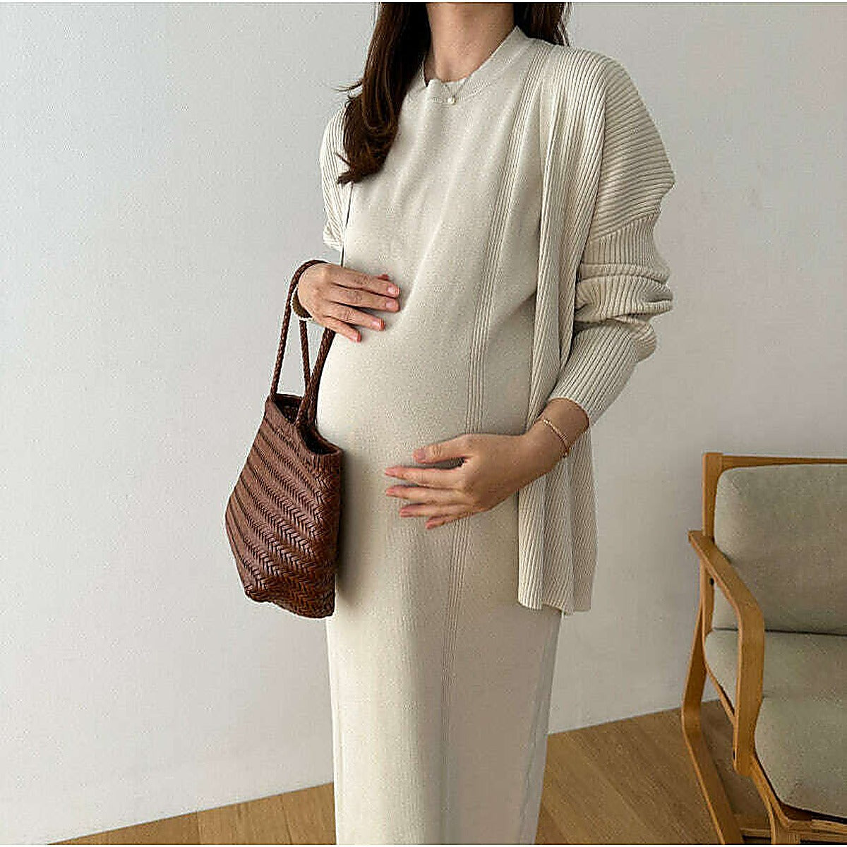 模特兒實穿米白針織連身長裙配同色開襟外套，手持棕色編織袋，室內半全身｜羅紋披肩開衫孕婦裙套裝（第 2 張）