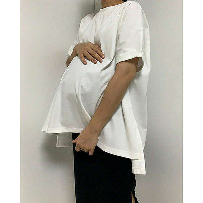 模特兒實穿白色 T 恤配黑色短褲，站於鏡前｜反袖A字寬鬆前短後長上衣（第 12 張）