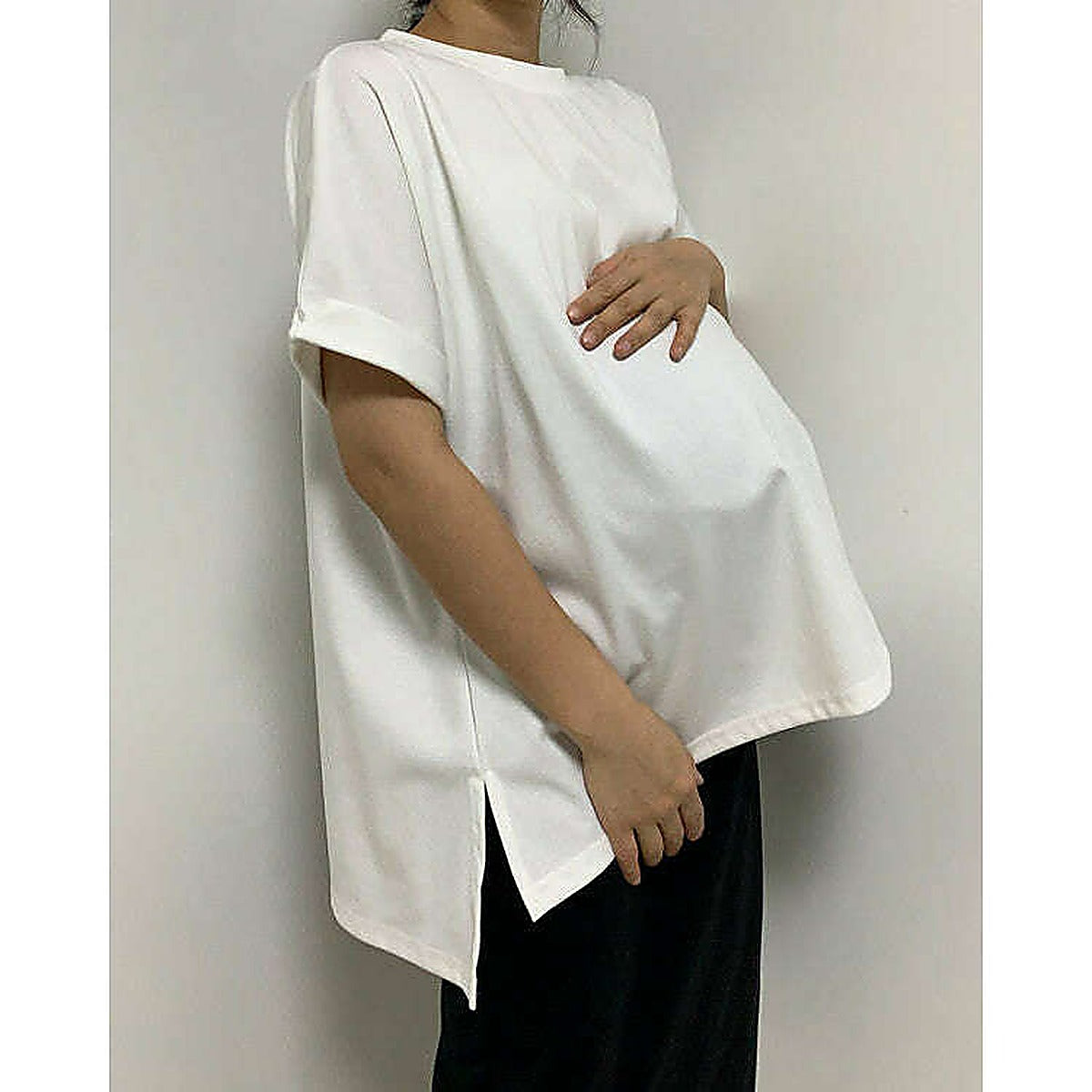 模特兒實穿白色 T 恤配黑色短褲，站於鏡前｜反袖A字寬鬆前短後長上衣（第 14 張）