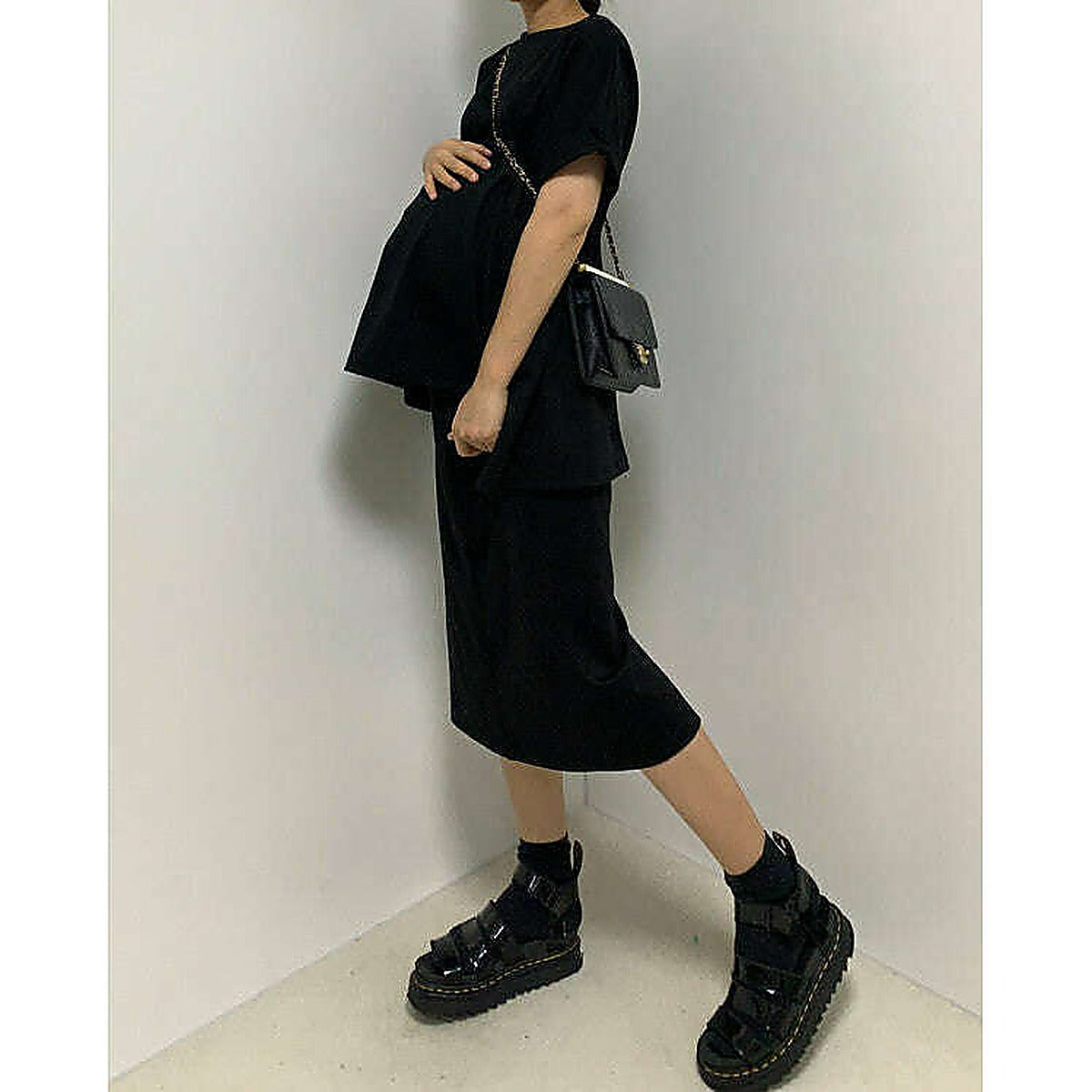 模特兒實穿白色 T 恤配黑色短褲，站於鏡前｜反袖A字寬鬆前短後長上衣（第 34 張）
