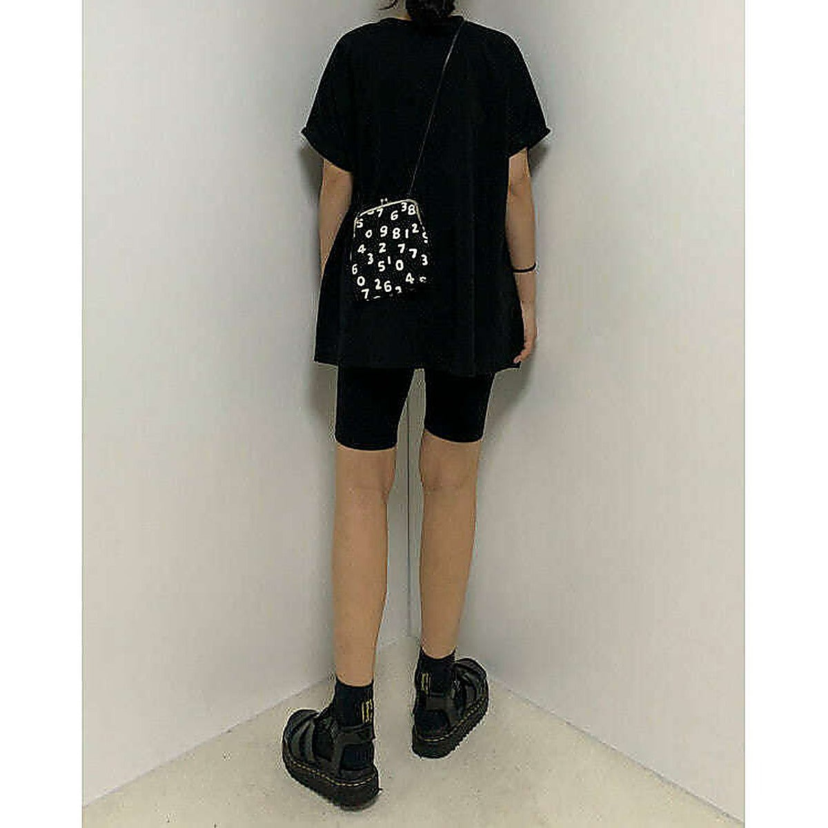 模特兒實穿白色 T 恤配黑色短褲，站於鏡前｜反袖A字寬鬆前短後長上衣（第 36 張）