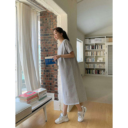 模特兒實穿淺灰短袖連身裙（側開衩），窗邊全身、手持藍色書本｜圓領素色側開衩連身裙（第 2 張）