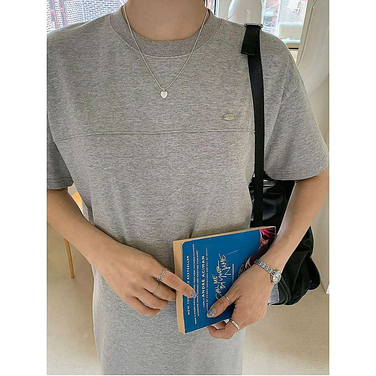 灰色針織連身裙，圓領短袖及膝長度，模特手拿書本肩背黑包示範｜圓領素色側開衩連身裙（第 324 張）